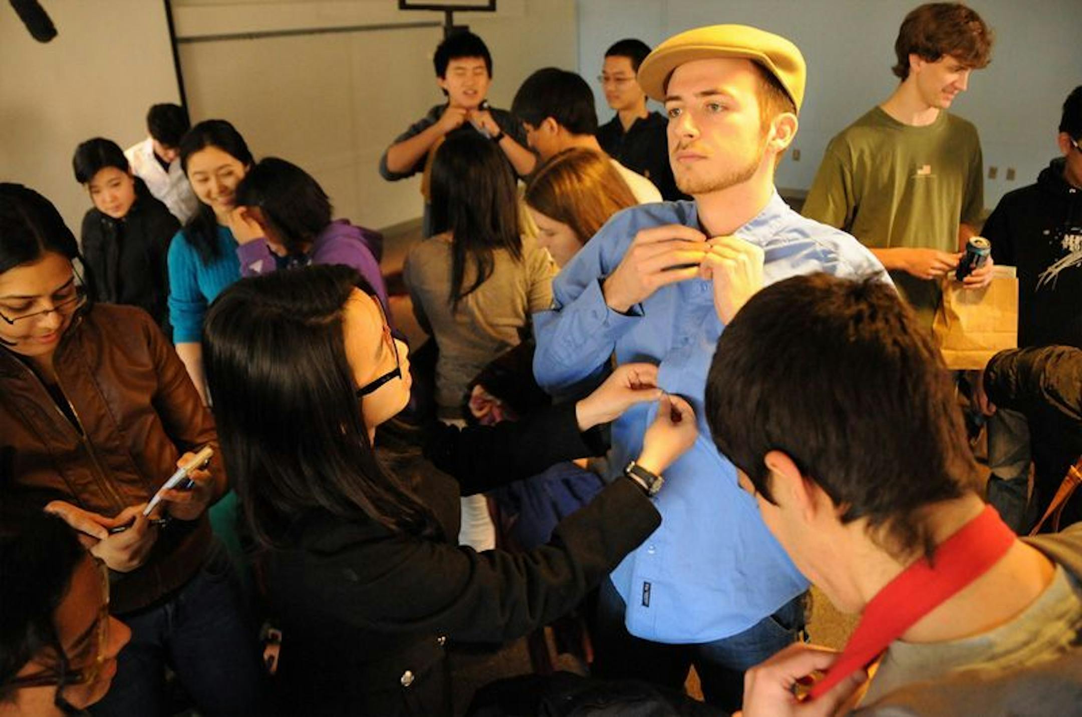 Michelle Chen (left) helps dress Jay McKenna (right) during "Dress for Success," a short class about how to dress on the job or for an interview, at MIT's 2012 Charm School.
