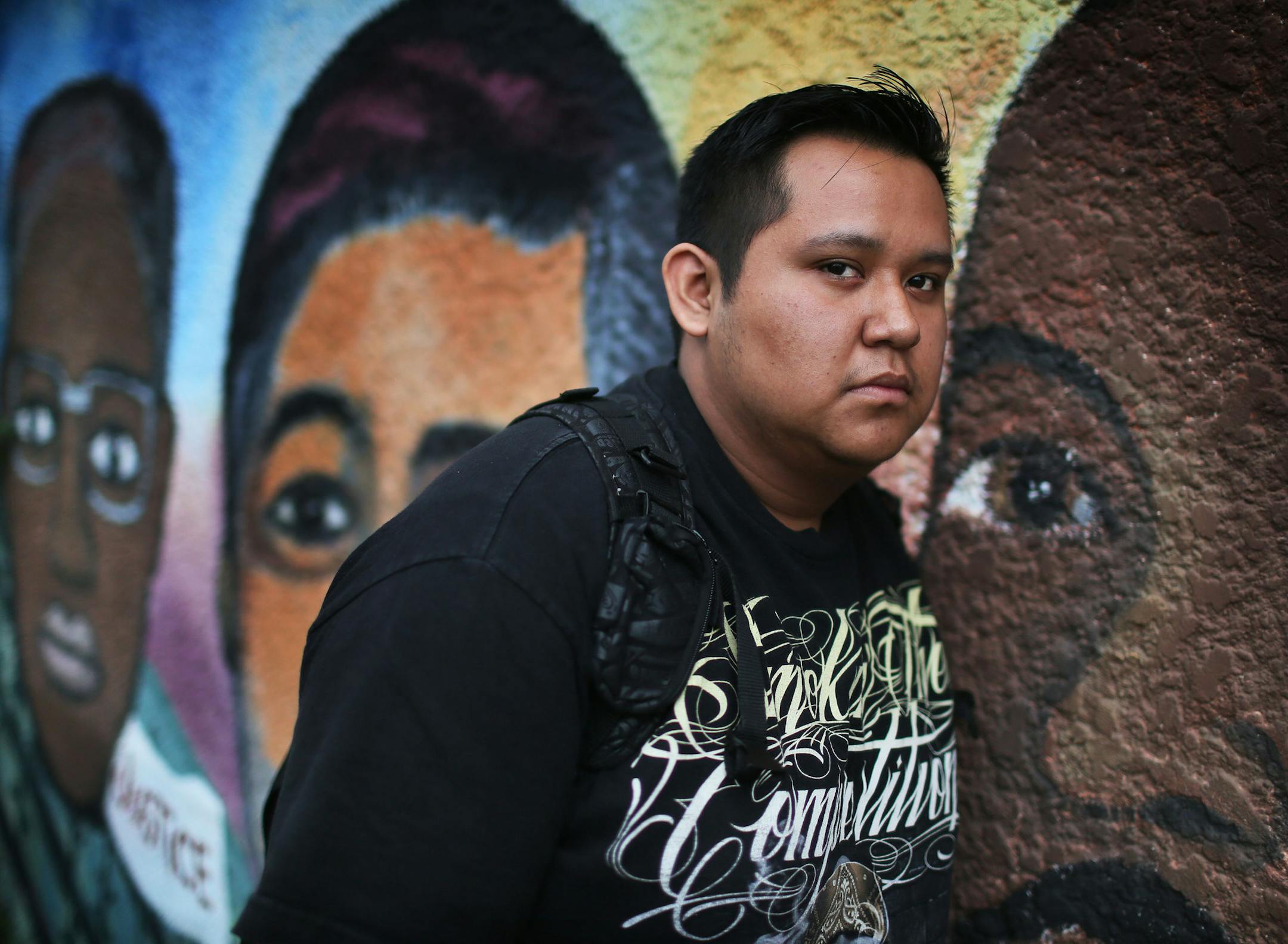 High School student Angel Onefre is graduating from El Colegio Charter School after a turbulent childhood that includes having his father deported back to the family's native Mexico and then his mother leaving back to Mexico as well. Onefre ended up staying and helping raise himself, along with the help of several older sisters. He was seen near student-painted murals outside the school Friday, June 29, 2015 in Minneapolis, MN.](DAVID JOLES/STARTRIBUNE)djoles@startribune.com High School graduate