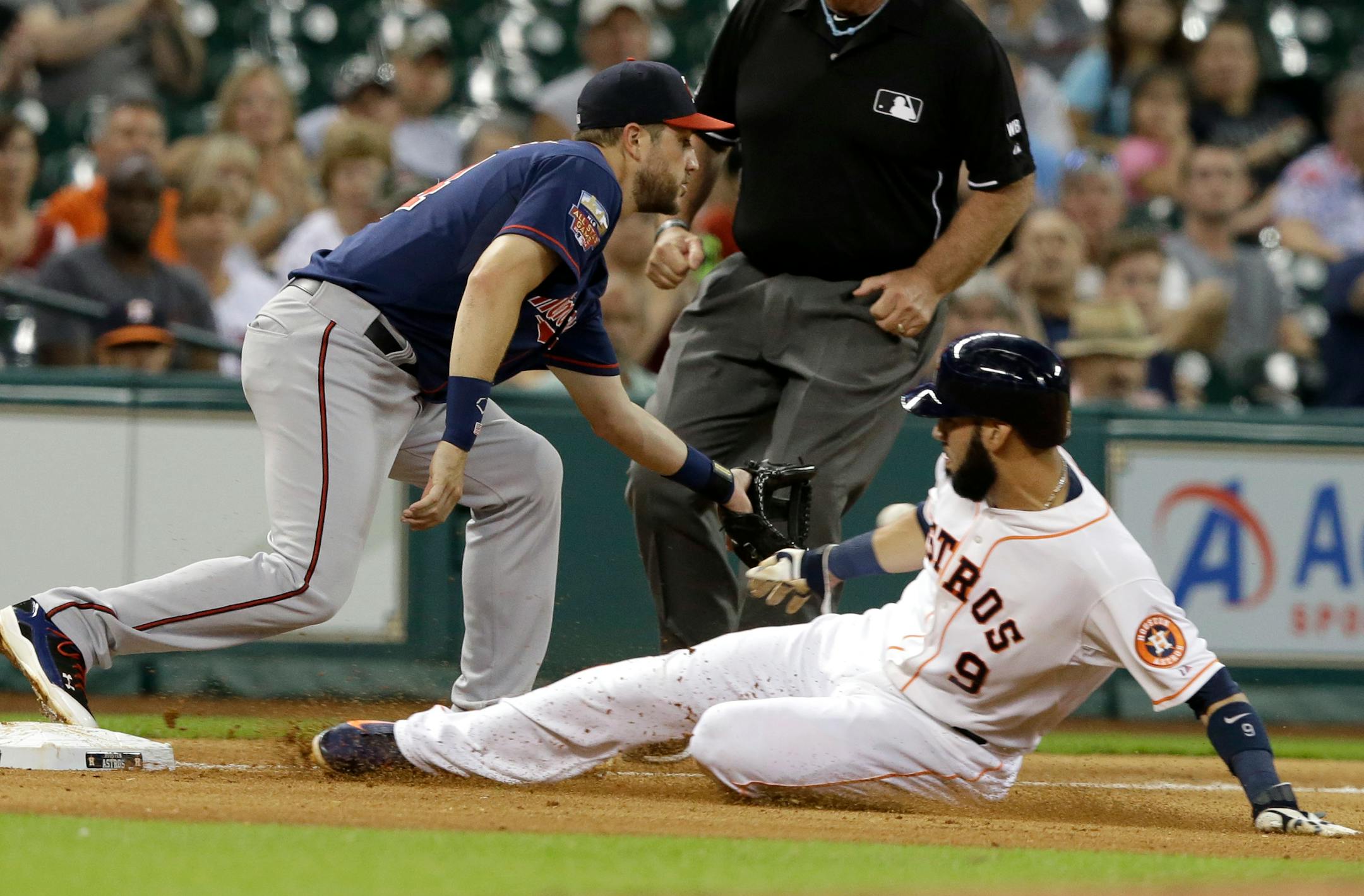 Houston Astros' Marwin Gonzalez (9) is safe at third base as Minnesota Twins third baseman Trevor Plouffe reaches for the ball in the the fifth inning of a baseball game Tuesday, Aug. 12, 2014, in Houston. Gonzalez came from first base on a Robbie Grossman single. (AP Photo/Pat Sullivan)