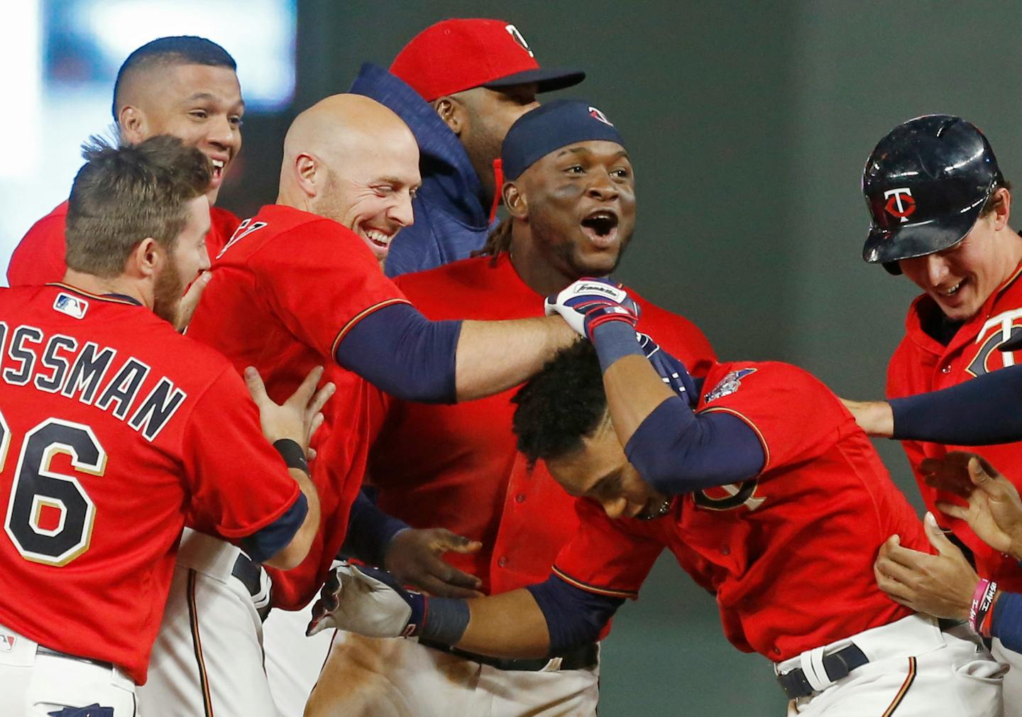 Minnesota Twins' Jorge Polanco, right, is swarmed by teammates after his walk-off sacrifice fly in the 10th inning of a baseball game against the Kansas City Royals on Friday, May 19, 2017, in Minneapolis. The Twins won 4-3. (AP Photo/Jim Mone)