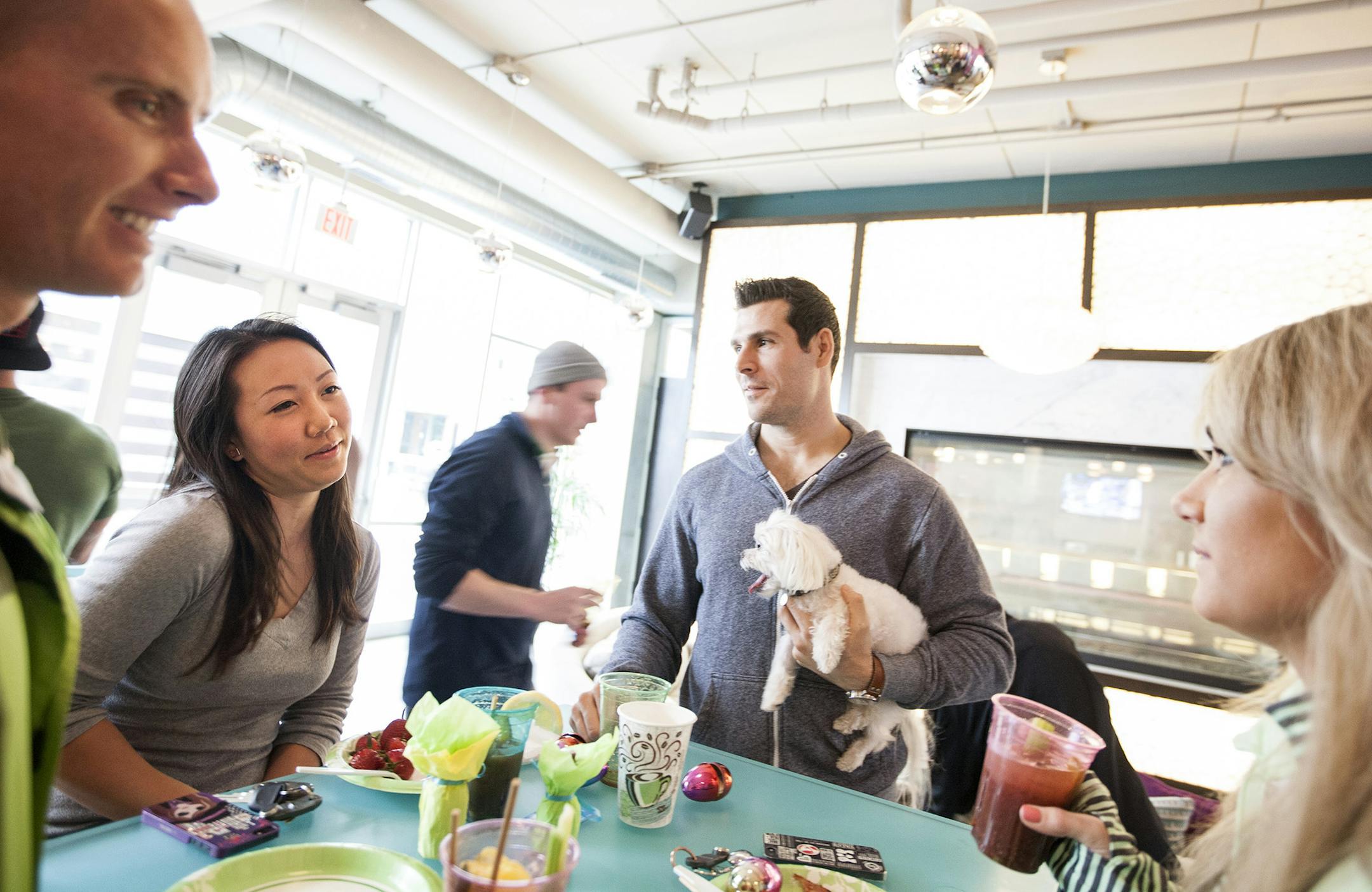 Left to right, John Hoel, Pat Leksrisompong, Dave Sieber with his dog Leo, and Brookley Wofford talk at a Bloody Mary brunch party at Flux apartments in Uptown April 18, 2014. (Courtney Perry/Special to the Star Tribune)