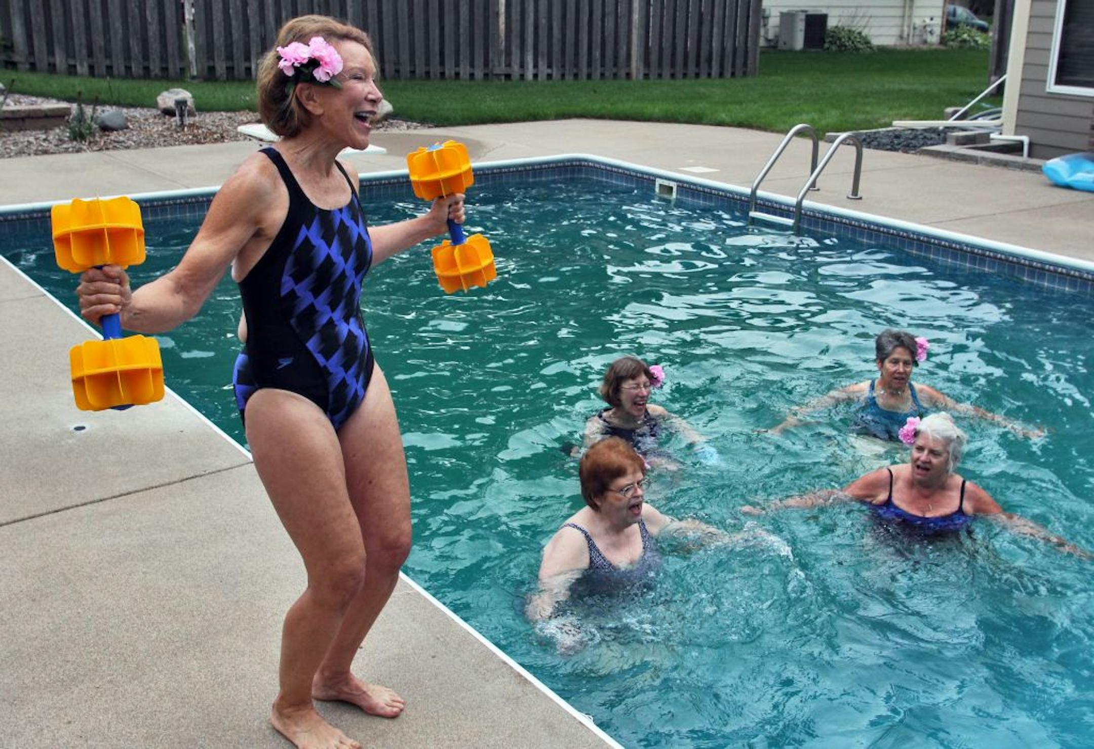 Wendy Louise leads a aqua-aerobics 'sing-along' class working with water weights at L A Fitness. Louise, left, recently led a smaller group at a Bloomington neighborhood pool.