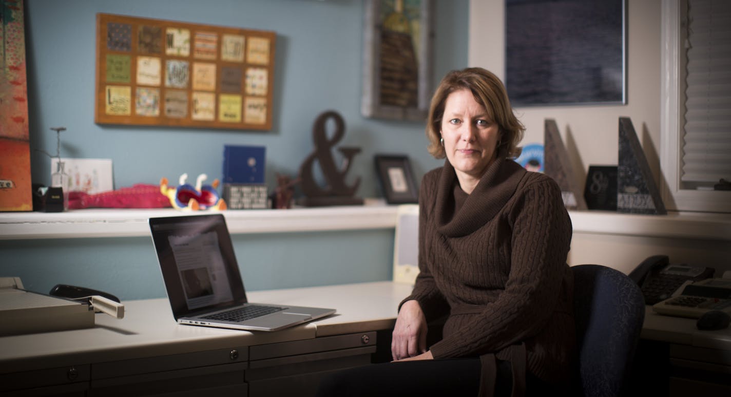 Joy Baker in her home office in New London, Minn. An inspirational quote on the wall says, &#x201c;She knew the answers would come with time and love.&#x201d;