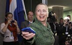 FILE - In this Dec. 8, 2011, file-pool photo, then-Secretary of State Hillary Rodham Clinton hands off her mobile phone after arriving for a meeting i