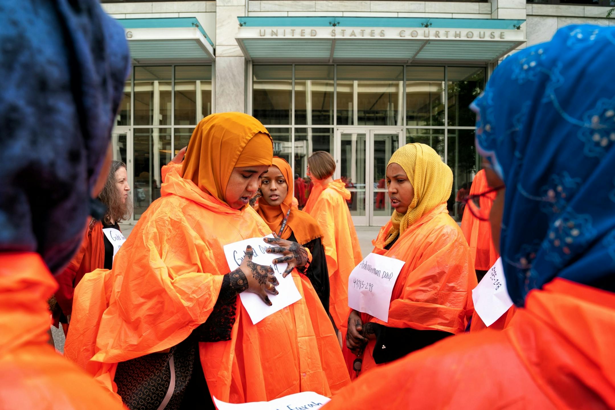 Protesters wore orange ponchos in solidarity with the three men being who were convicted in plotting to join ISIS. The men are appearing before a three-judge federal appeals court panel Thursday morning. Protesters were not allowed to enter the courthouse until the orange ponchos and signs bearing the names of the convicted men were removed.