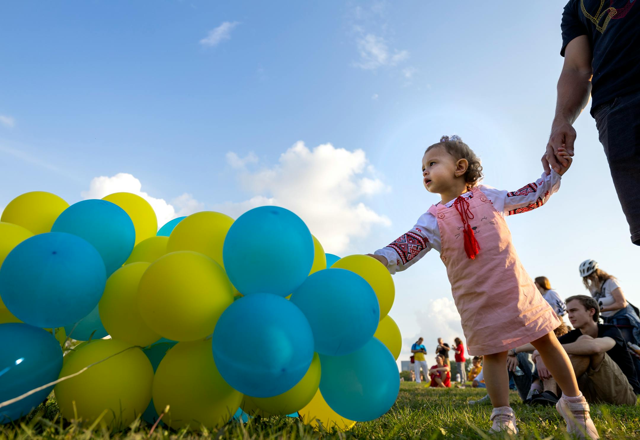 Alyssa lobzun, 2, played with balloons while holding her father's Dmytro Iobzun hand.