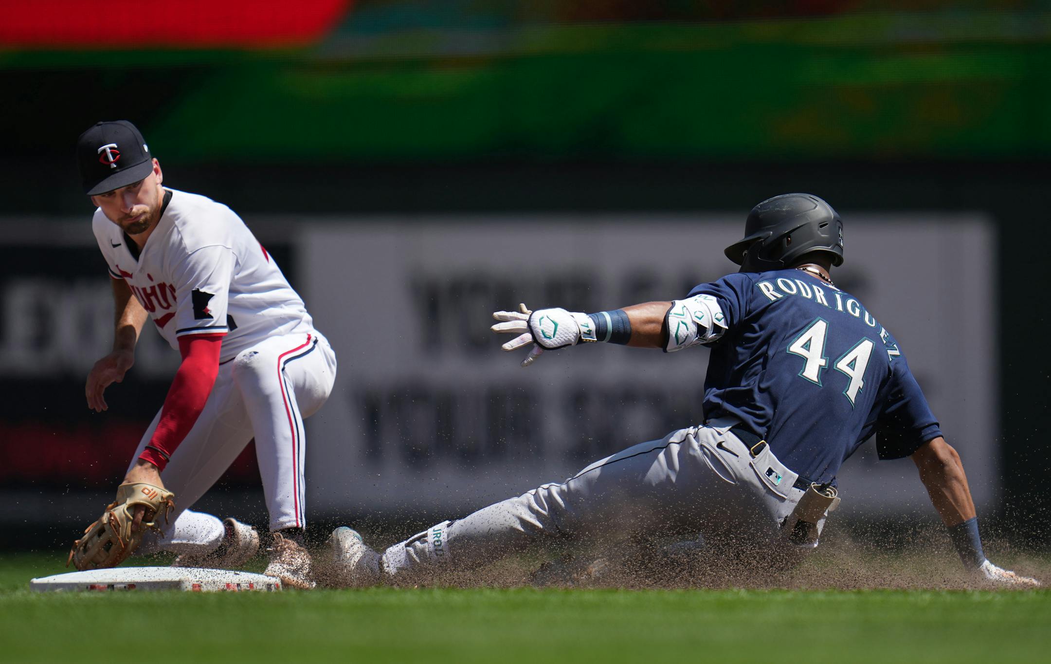 Seattle Mariners center fielder Julio Rodriguez (44) slides safely into second on a double in the sixth inning as Minnesota Twins second baseman Edouard Julien (47) is late with the tag in Minneapolis, Minn.