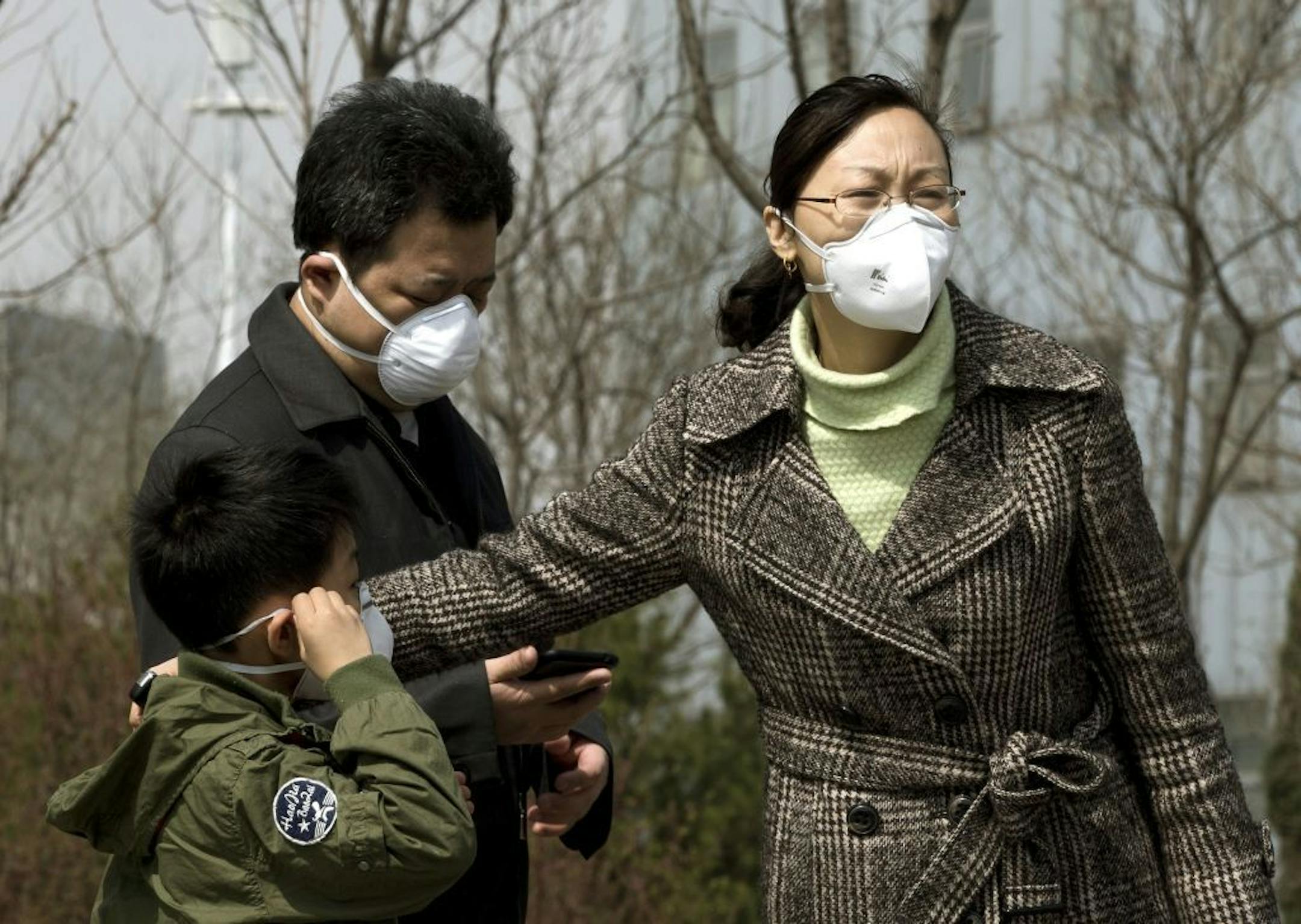 April 14, 2013: Chinese family wears face masks near a hospital in Beijing where a Chinese girl is being treated for the H7N9 strain of bird flu.