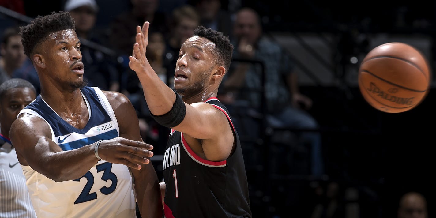 Jimmy Butler (23) passed the ball while being defended by Evan Turner (1) in the first quarter. ] CARLOS GONZALEZ &#xef; cgonzalez@startribune.com - December 18, 2017, Minneapolis, MN, Target Center, NBA, Basketball, Minnesota Timberwolves vs. Portland Trail Blazers