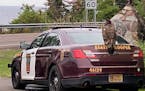A juvenile bald eagle perches atop a Minnesota State Trooper vehicle as authorities try to move the bird away from Cascade Lodge resort on Highway 61,