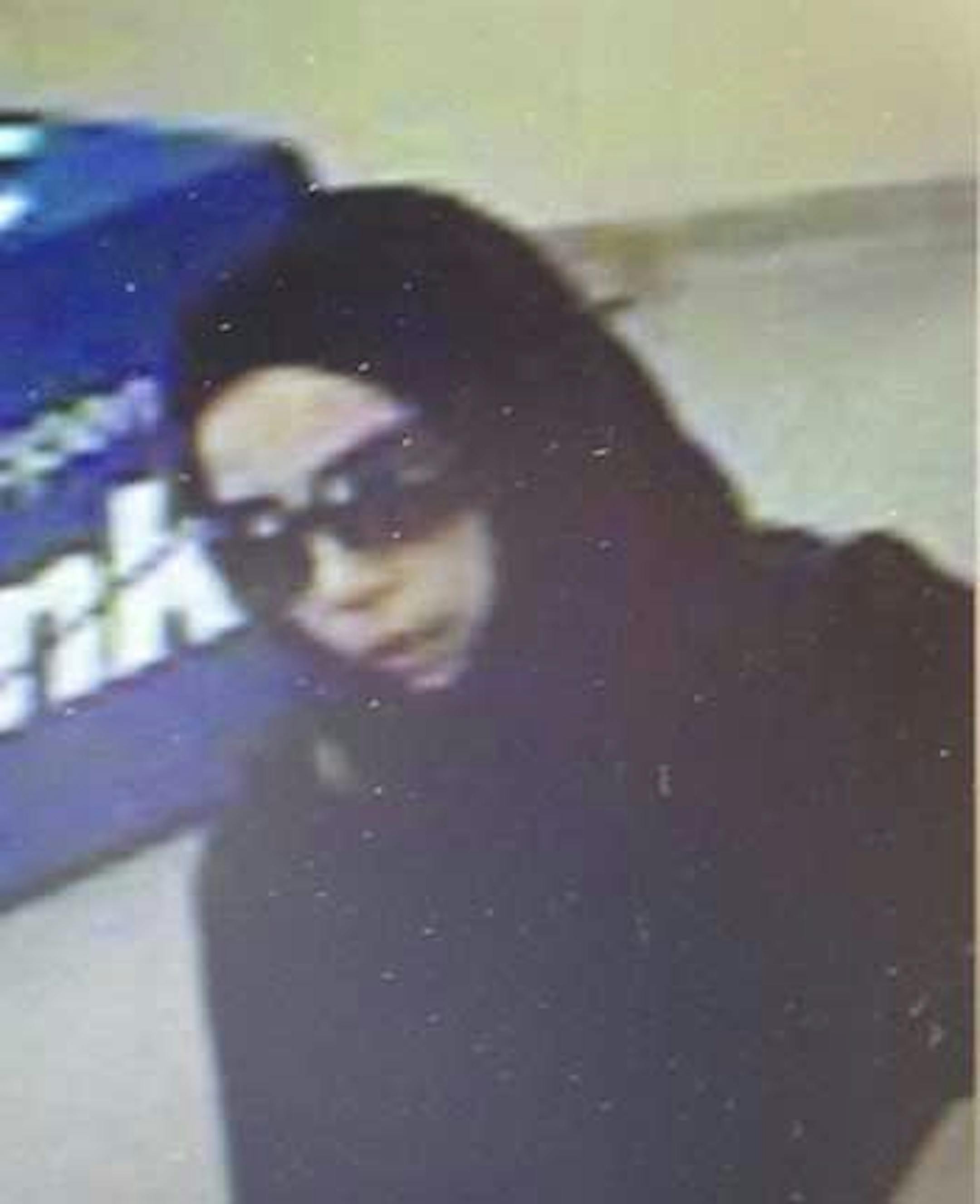 A woman dressed in black right down to her scarf and sunglasses is believed responsible for holding up two banks on successive Thursdays on the outskirts of the Twin Cities area. This photo shows the robber at the bank in Cologne.