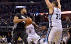 Minnesota Timberwolves forward Karl-Anthony Towns, left, drives against Memphis Grizzlies forward JaMychal Green (0) and center Marc Gasol (33) in the