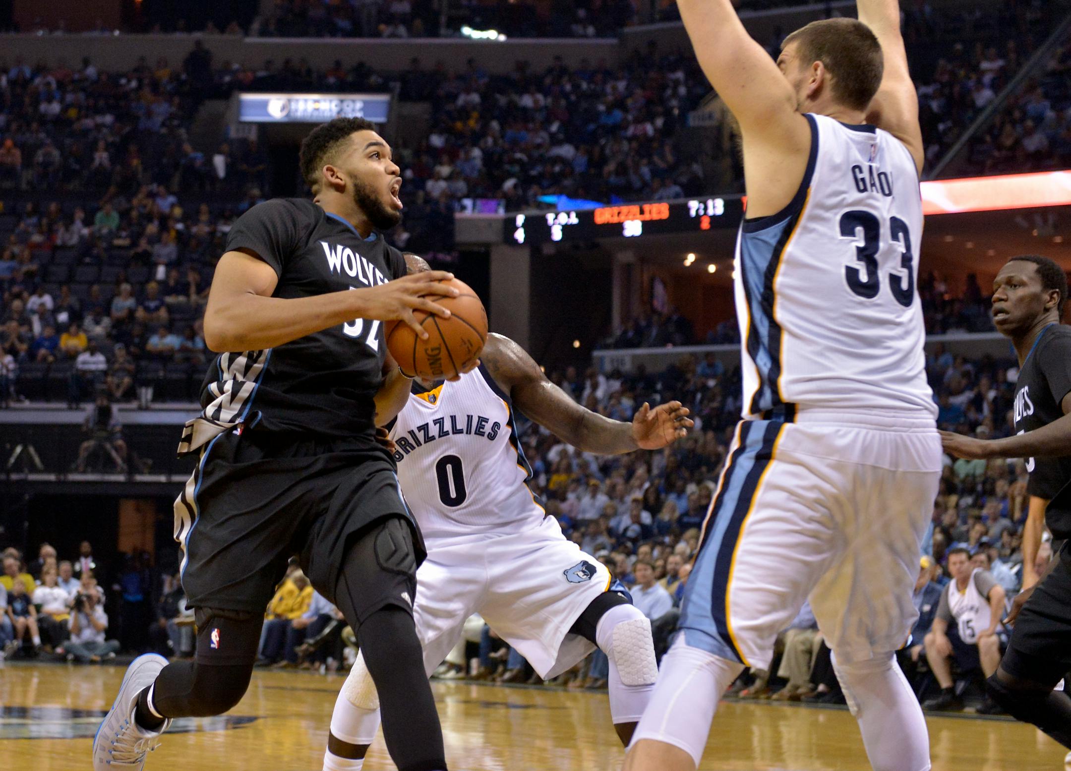Minnesota Timberwolves forward Karl-Anthony Towns, left, drives against Memphis Grizzlies forward JaMychal Green (0) and center Marc Gasol (33) in the first half of an NBA basketball game Wednesday, Oct. 26, 2016, in Memphis, Tenn. (AP Photo/Brandon Dill)