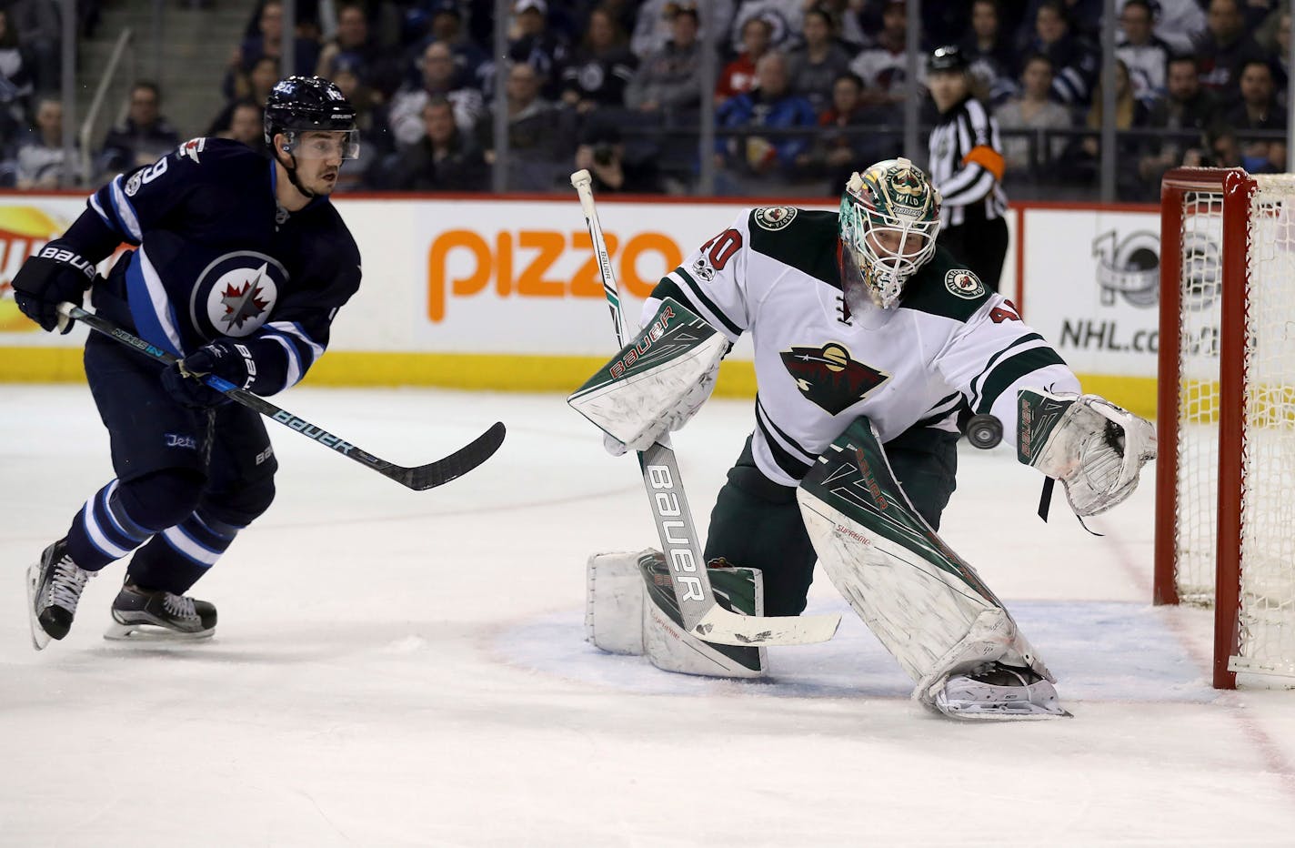 Minnesota Wild goalie Devan Dubnyk (40) looks to make a glove save in front of Winnipeg Jets left wing Nic Petan (19) during the second period of an NHL hockey game Tuesday, Feb. 7, 2017, in Winnipeg, Manitoba. (Trevor Hagan/The Canadian Press via AP)