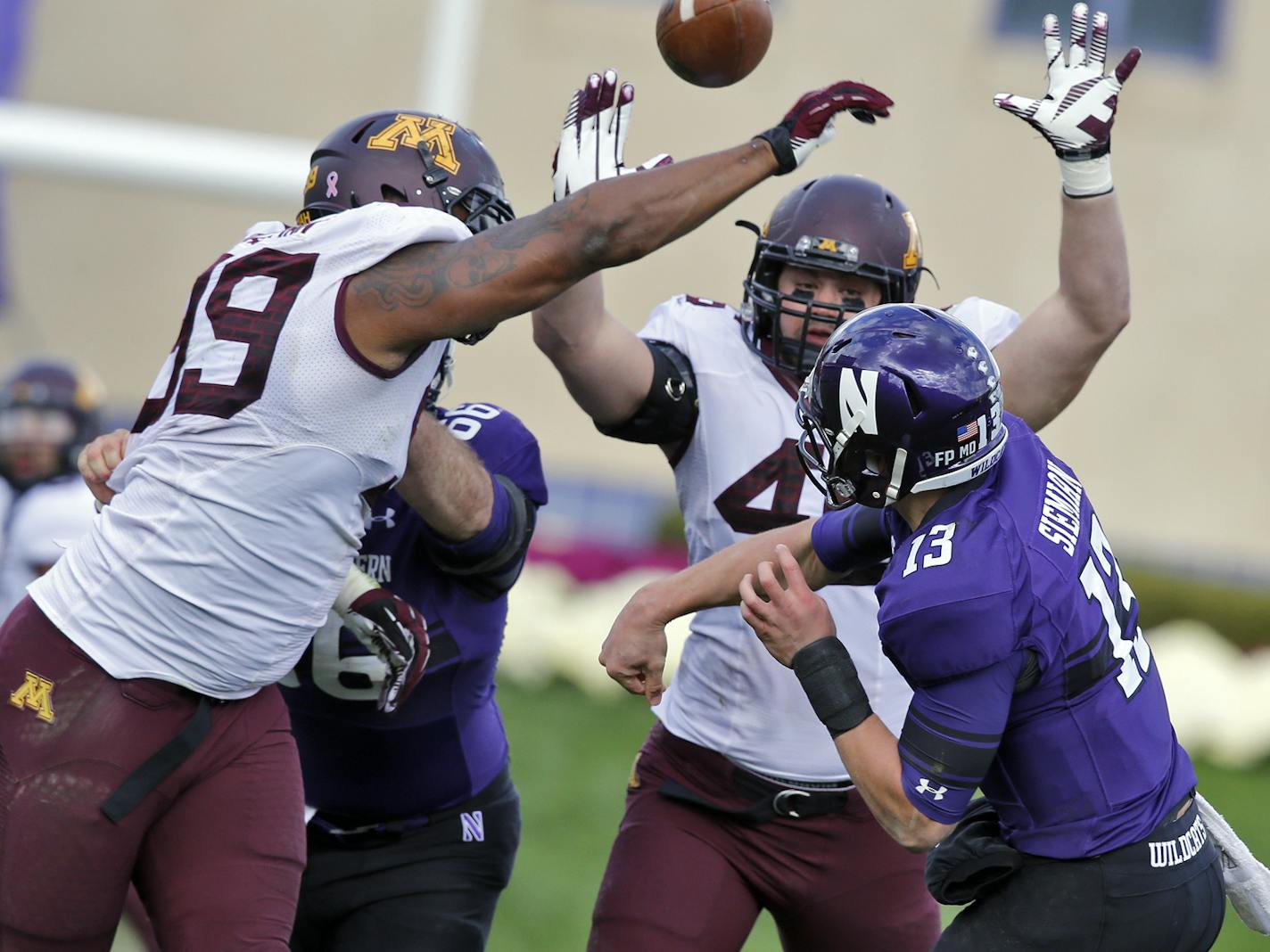 Minnesota Gophers vs. Northwestern Wildcats football. Minnesota won 20-17. Minnesota defenders Ra'Shede Hageman, left, and Cameron Botticelli knocked down a pass attempt by Wildcats quarterback Trevor Siemian in 2nd half action. . (MARLIN LEVISON/STARTRIBUNE(mlevison@startribune.com)