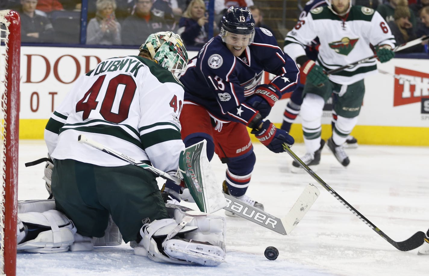 Minnesota Wild's Devan Dubnyk, left, makes a save against Columbus Blue Jackets' Cam Atkinson during the second period of an NHL hockey game Thursday, March 2, 2017, in Columbus, Ohio.