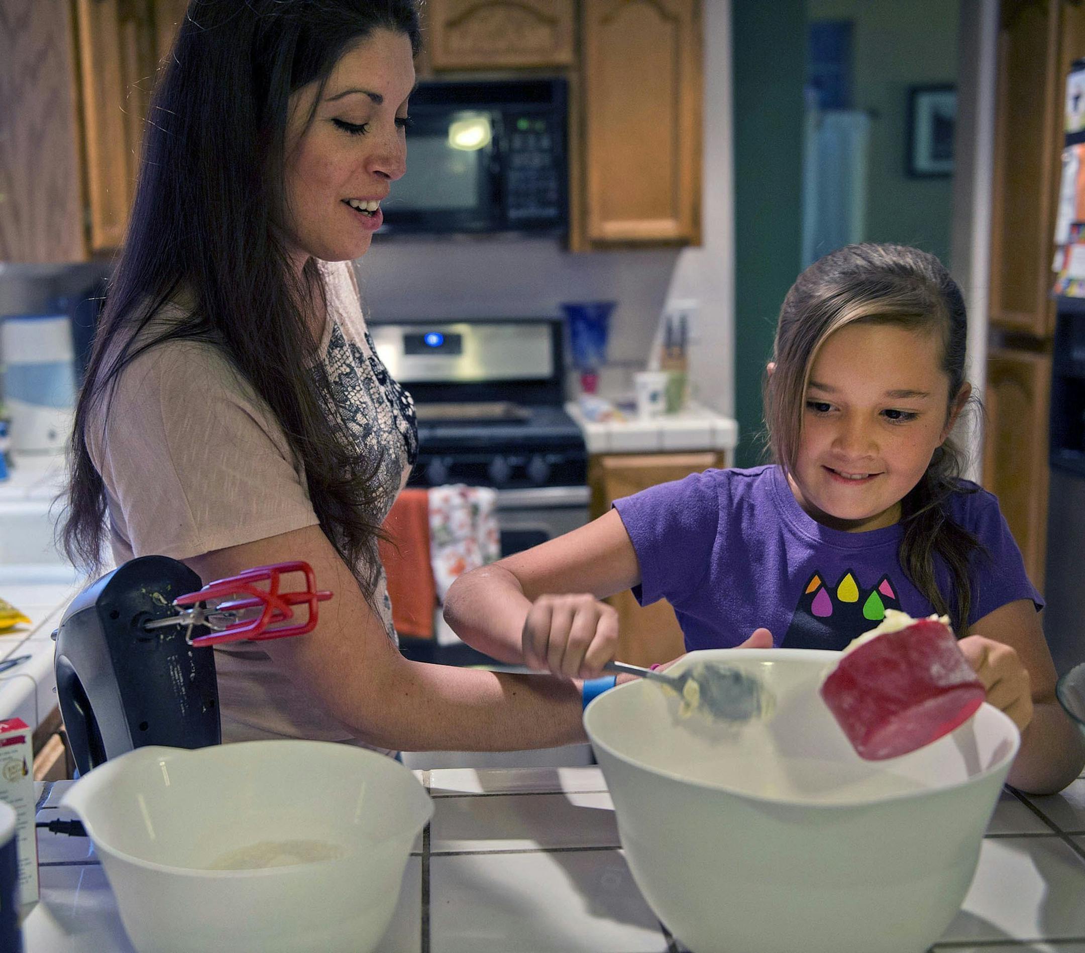 Evan Whisenant, 10, makes cookies with her mom, Shannon, at home in Antelope, Calif., on Nov. 26, 2013. Evan beat leukemia five years ago but still suffers from side effects of the treatments.