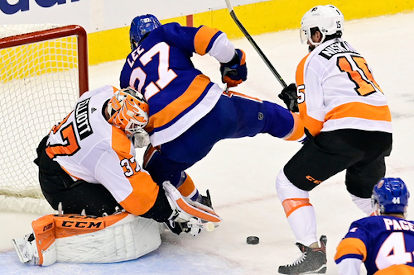 New York Islanders left wing Anders Lee (27) crashes into Philadelphia Flyers goaltender Brian Elliott (37) as Flyers defenseman Matt Niskanen (15) defends during the third period of an NHL Stanley Cup Eastern Conference playoff hockey game, Sunday, Aug. 30, 2020, in Toronto. (Frank Gunn/The Canadian Press via AP)