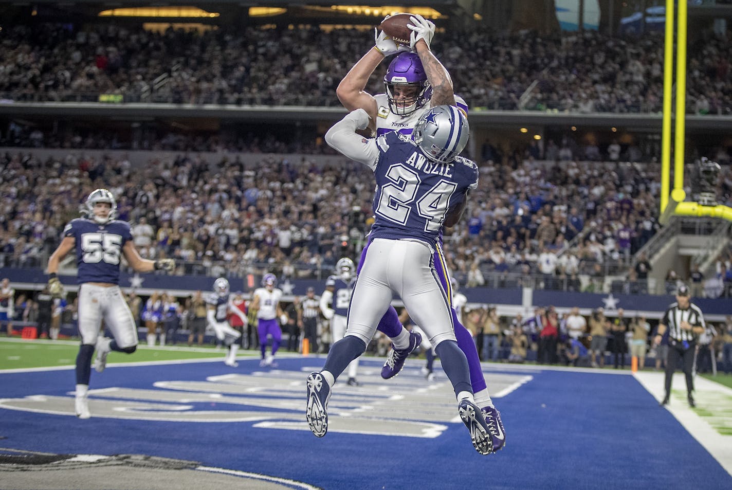 Minnesota Vikings' tight end Kyle Rudolph caught the ball in the end zone for a two-point conversion despite defensive pressure from Dallas Cowboys' cornerback Chidobe Awuzie during the third quarter.