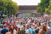 Thousands of people move down Liggett Street on the first day of the 2023 Minnesota State Fair in Falcon Heights.
