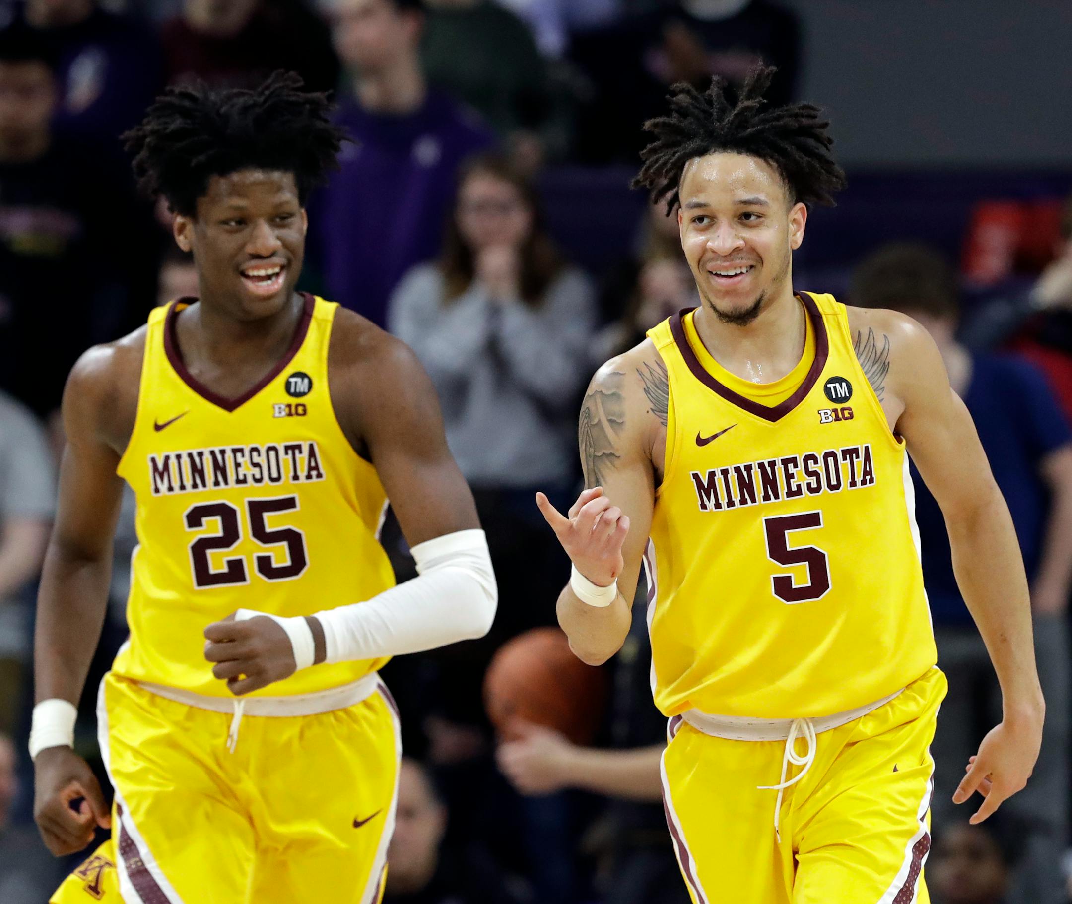 Gophers guard Amir Coffey, right, smiles after scoring a basket as he runs with center Daniel Oturu during the second half