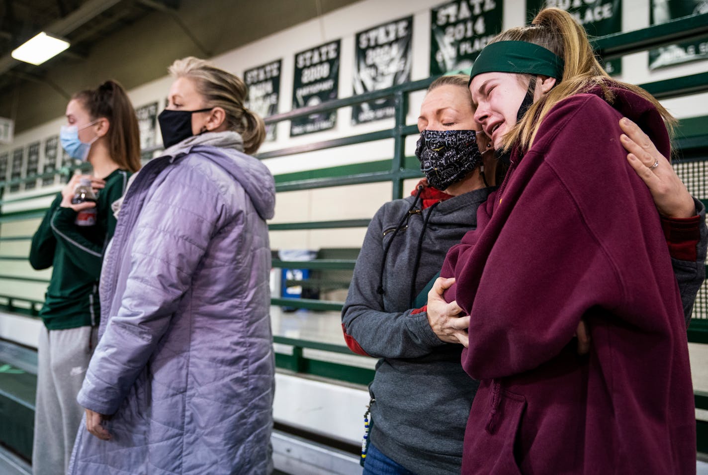 Emma Wasiloski, 13, an eighth grader at North Heights Christian Academy who plays for Concordia Academy's C volleyball team and elite club volleyball, cried in the arms of her mother MaryBeth Wasiloski after hearing the news that the volleyball season would be paused