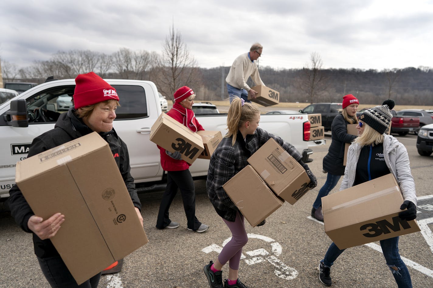 Registered nurse Kim Lutes left, and others carried 1,200 N95 masks donated by Rich Forstner, president of White Bear Lake contracting firm Mavo Systems on Sunday, March 22.