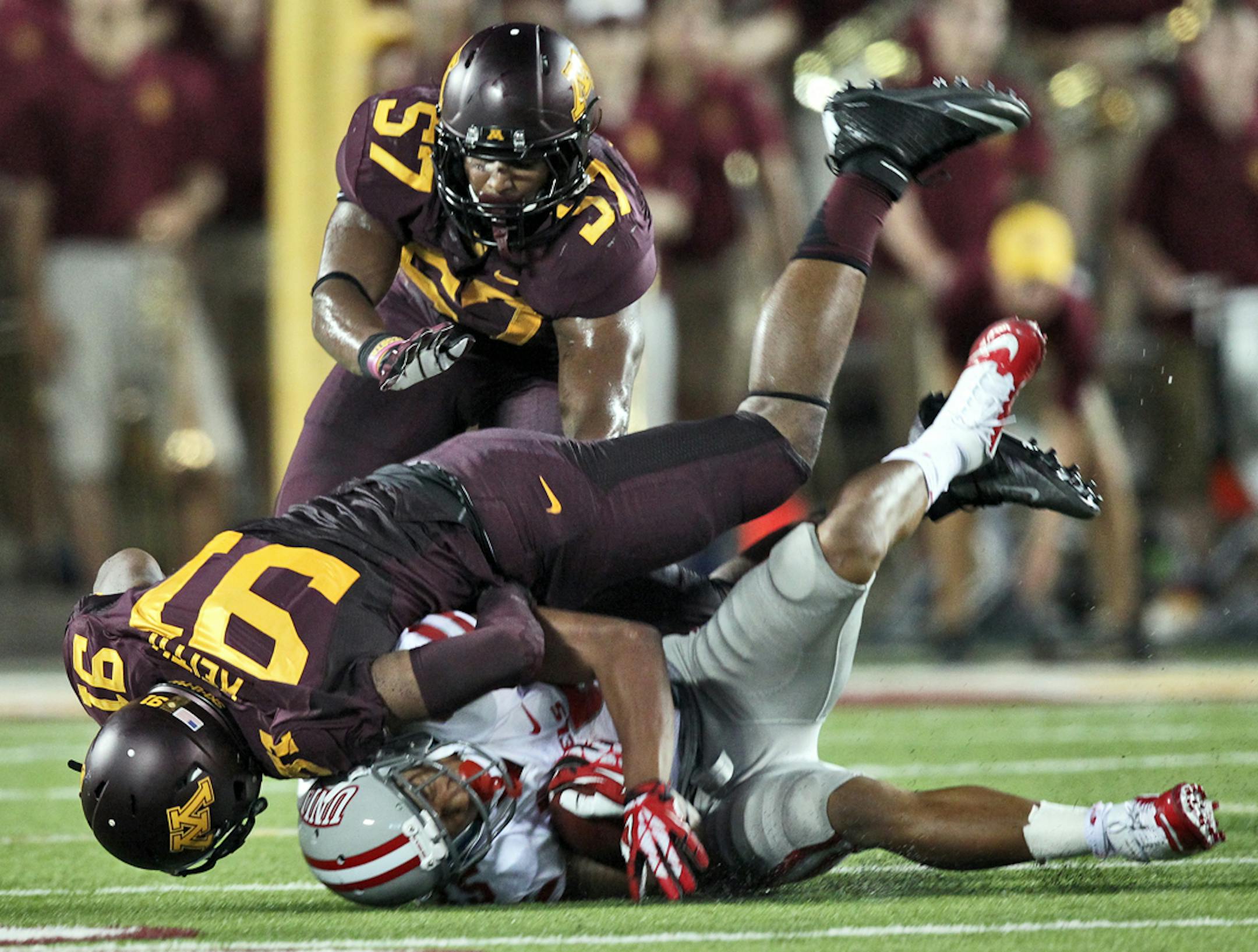 Minnesota Gophers vs. UNLV. Minnesota won 51-23. Minnesota defenders Alex Keith, left, and Aaron Hill (57) threw UNLV running back Tim Cornett for a loss ion 2nd half action.