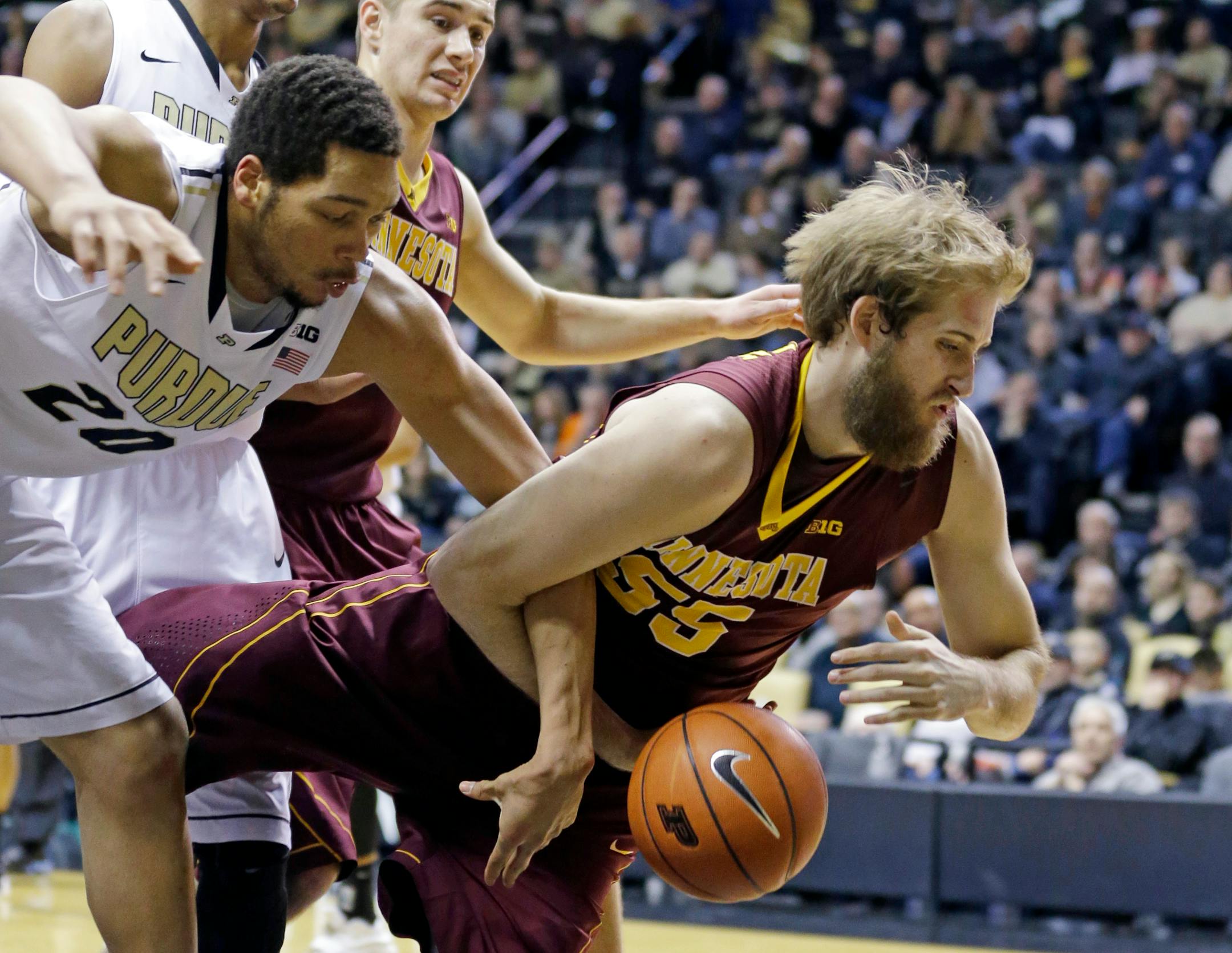 Minnesota center Elliott Eliason (55) and Purdue center A.J. Hammons (20) battle for a loose ball in the second half of an NCAA college basketball game in West Lafayette, Ind., Wednesday, Dec. 31, 2014. Purdue defeated Minnesota 72-68. (AP Photo/Michael Conroy)