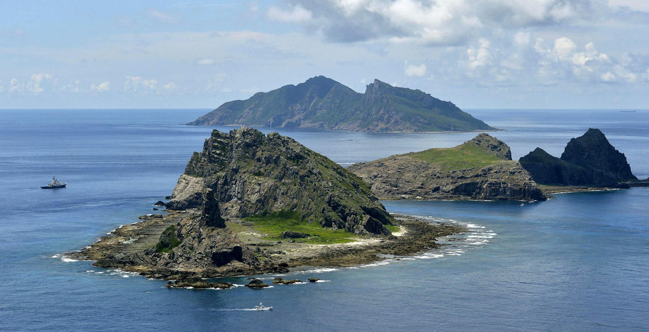 FILE - In this Sept. 2, 2012 file photo, the survey ship Koyo Maru, left, chartered by Tokyo city officials, sails around Minamikojima, foreground, Kitakojima, middle right, and Uotsuri, background, the tiny islands in the East China Sea, called Senkaku in Japanese and Diaoyu in Chinese. South Korean and Japanese flights through China‚Äôs new maritime air defense zone added to the international defiance Thursday, Nov. 28, 2013, of rules Beijing says it has imposed in East China