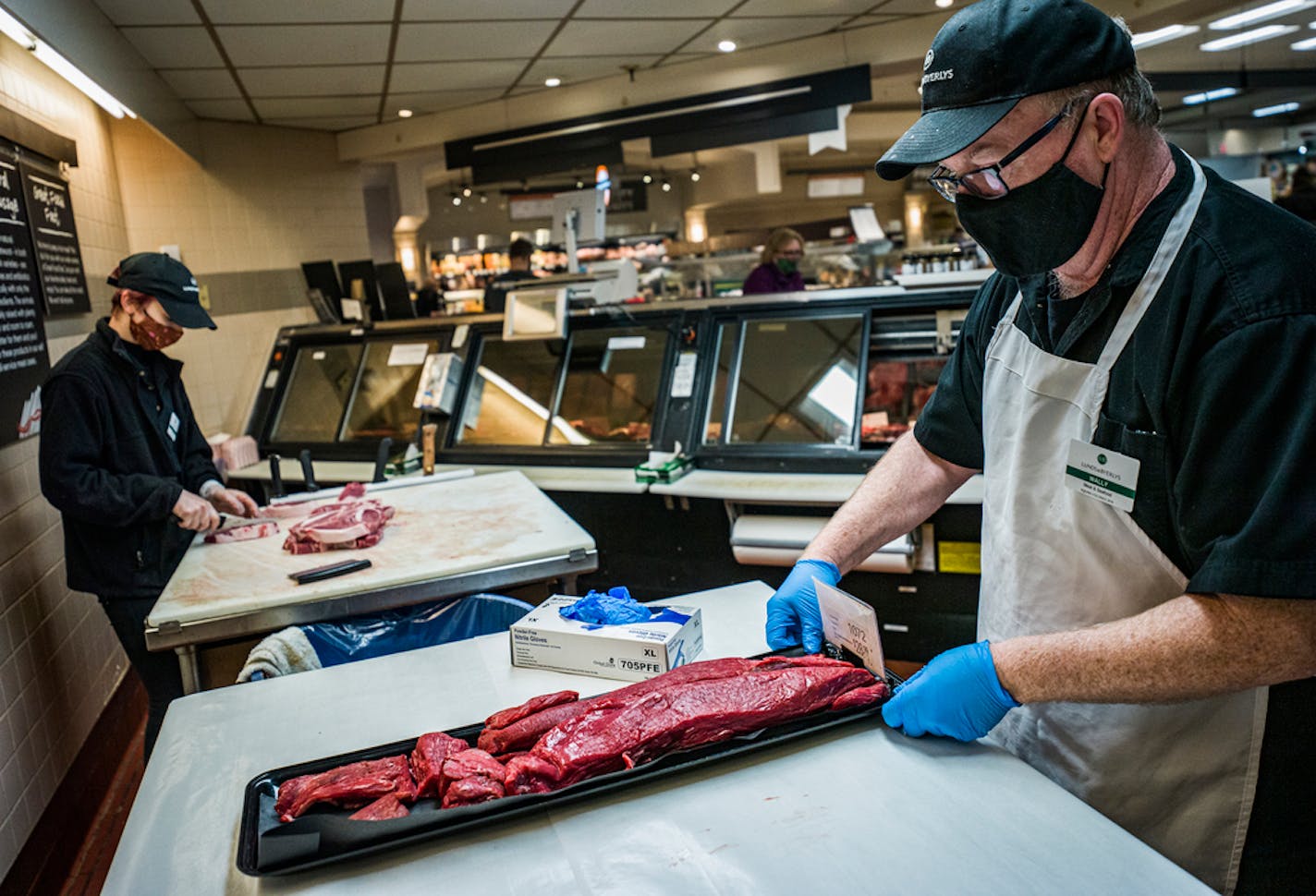 Meat cutter Mark Walfoort donned personal protective equipment while displaying tenderloin beef at a Lunds & Byerlys in Roseville. Walfoort keeps 10 washable masks in rotation.