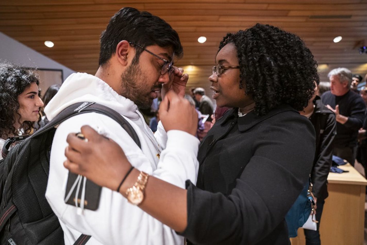 University of Minnesota student Jael Kerandi, right, comforts fellow student Nikil Badey after the meeting.