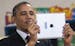President Barack Obama uses an iPad to take a picture at Buck Lodge Middle School in Adelphi, Md., Feb. 4, 2014. Obama visited the school to deliver r