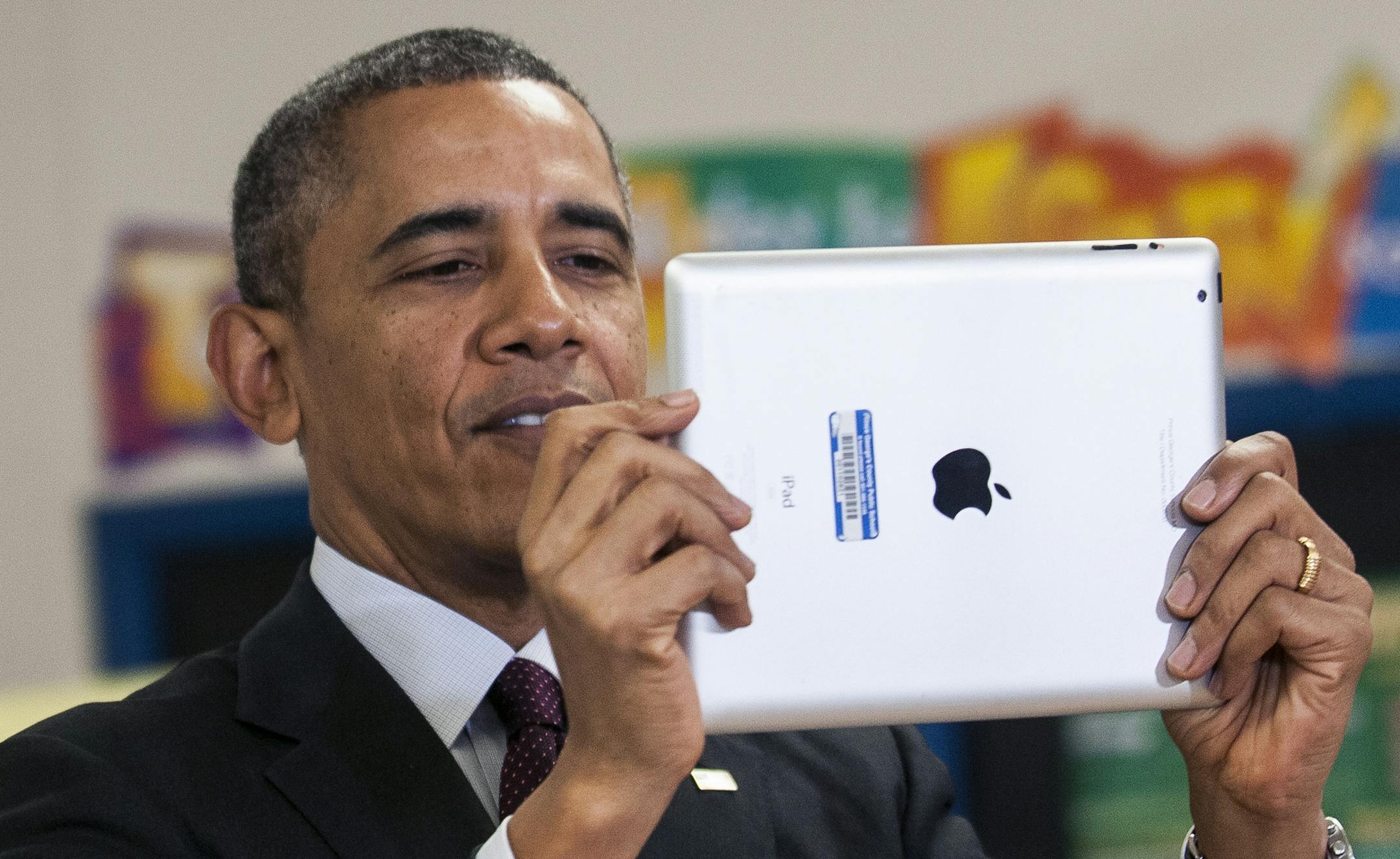President Barack Obama uses an iPad to take a picture at Buck Lodge Middle School in Adelphi, Md., Feb. 4, 2014. Obama visited the school to deliver remarks detailing the progress of the ConnectED initiative, which hopes bring high-speed internet access to 99 percent of American students within five years. (Gabriella Demczuk/The New York Times)