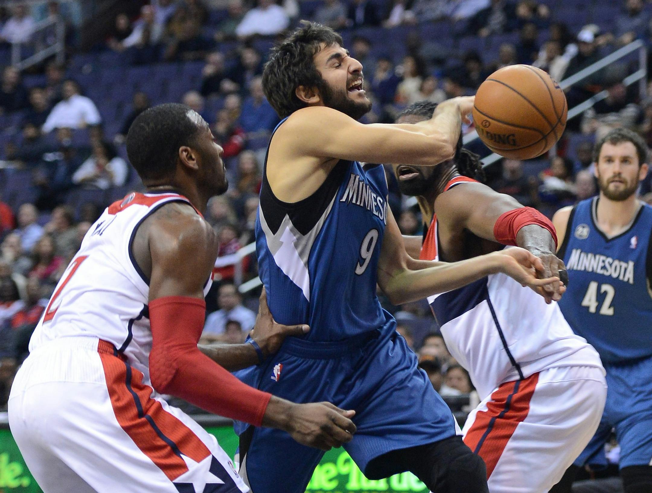Minnesota Timberwolves point guard Ricky Rubio (9) gets fouled by Washington Wizards point guard John Wall (2), as he drives the lane between Wall and Wizards power forward Nene Hilario (42), right, in the second quarter at the Verizon Center in Washington, Tue., Nov 19, 2013. (Chuck Myers/MCT)