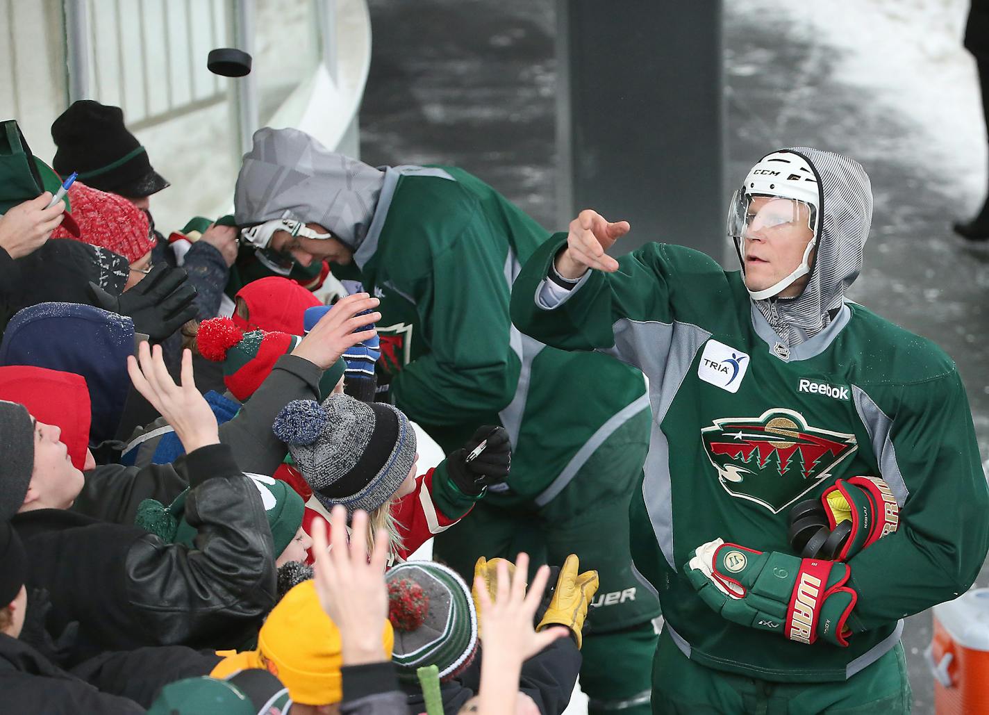 Mikko Koivu flips pucks to fans after practice at the Backyard outdoor ice rink at Braemar Arena.