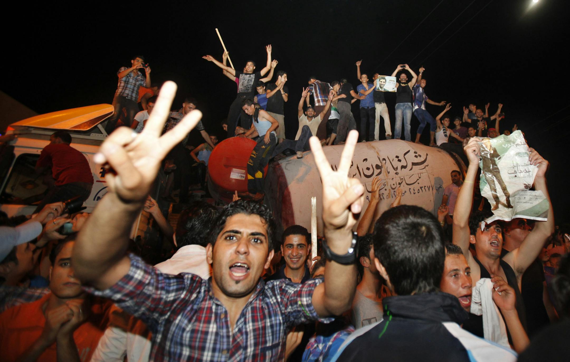 Palestinians chant slogans while holding pictures of Palestinian singer Mohammed Assaf as they celebrate his victory in a regional TV singing contest, along the streets of Gaza City, Saturday, June 22, 2013. Palestinians relished a rare moment of pride and national unity Saturday after the 23-year-old wedding singer from a refugee camp in the Gaza Strip won ìArab Idol,î a regional TV singing contest watched by millions of people. (AP Photo/Adel Hana)
