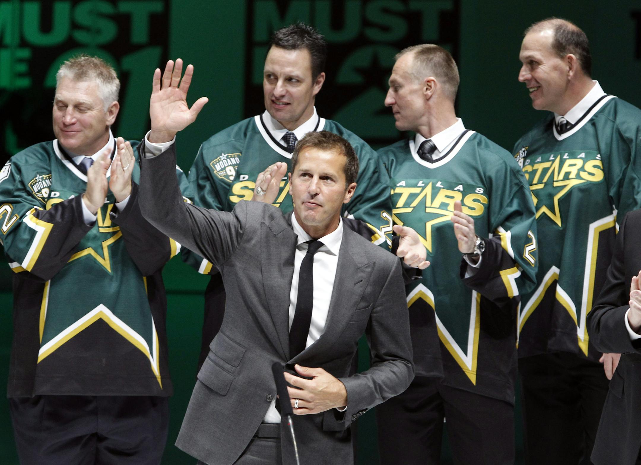 Former Dallas Stars player Mike Modano waves to the crowd during a jersey retirement ceremony before the Stars played the Minnesota wild in an NHL hockey game in Dallas on Saturday, March 8, 2014. (AP Photo/Richard W. Rodriguez)