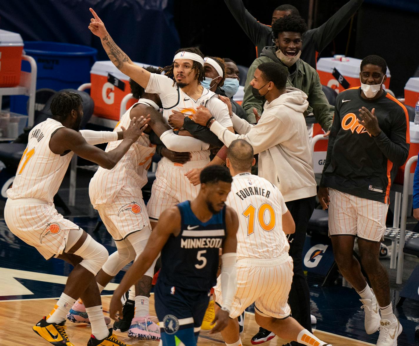 Teammates rushed to congratulate Magic guard Cole Anthony (50) after he hit a three pointer over Timberwolves guard Malik Beasley that won the game.