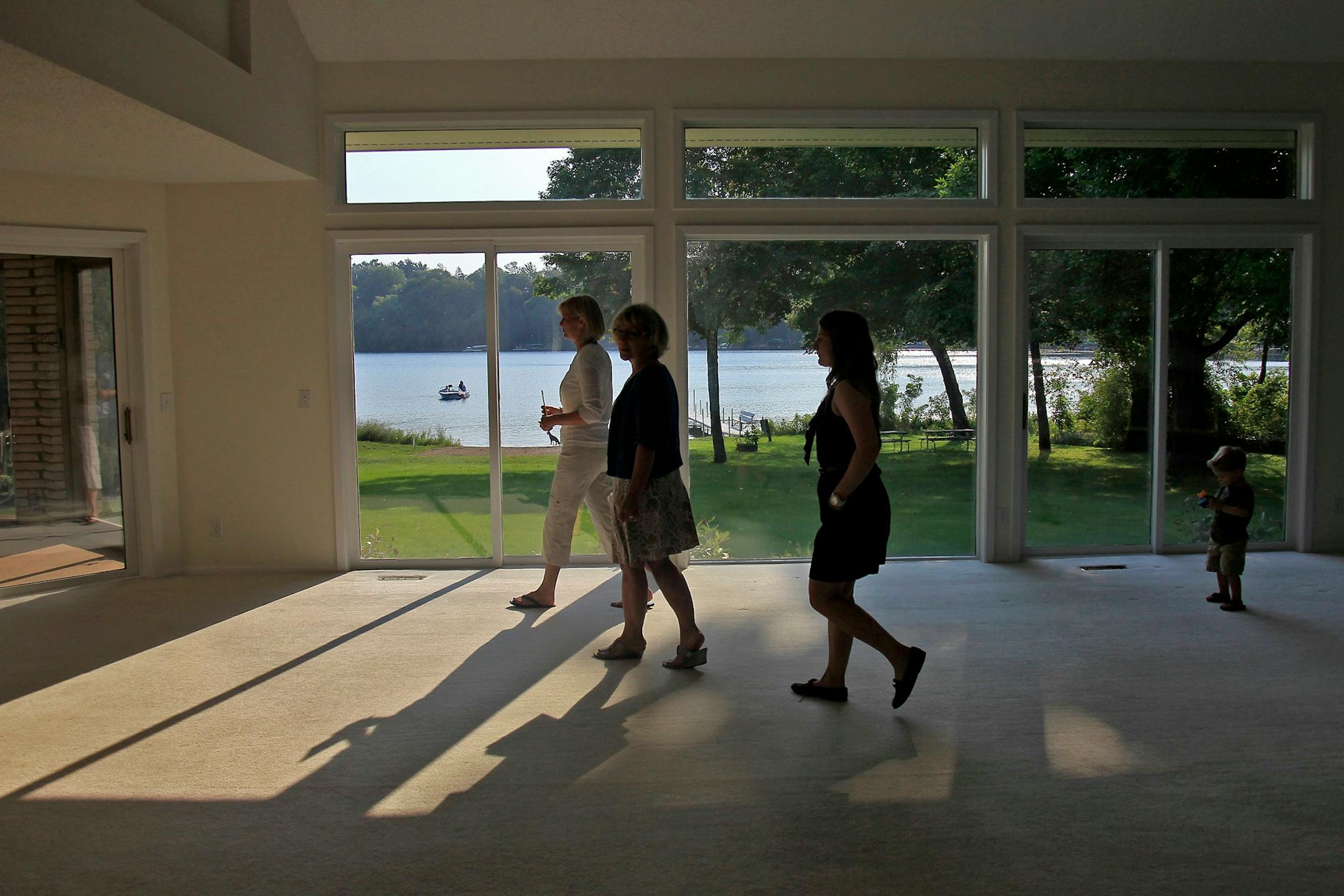 Realtor Virginia Lord, center, and assistant Jessica Pollock, right, gave a tour to Sandy Ryan, left, of the home she just purchased on Christmas Lake in Chanhassen, MN, Thursday, August 20, 2012. There is a huge increase in the number of lakeshore home sales this year. (ELIZABETH FLORES/STAR TRIBUNE) ELIZABETH FLORES � eflores@startribune.com