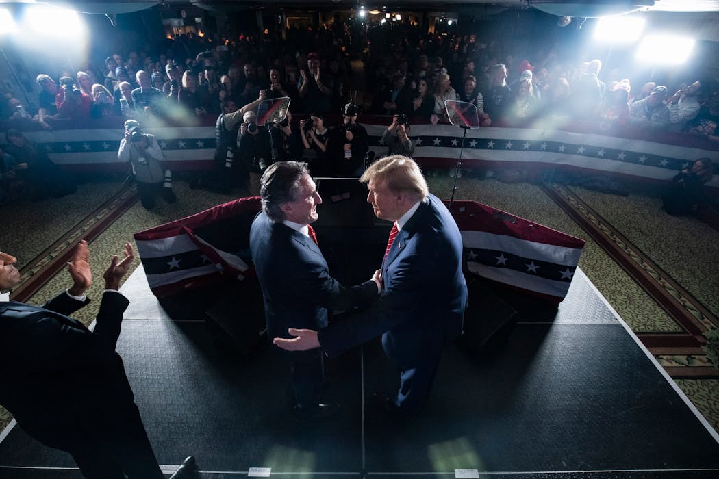 Former President Donald Trump shakes hands with North Dakota Gov. Doug Burgum (R), who is leading the Trump campaign’s development of its energy pol