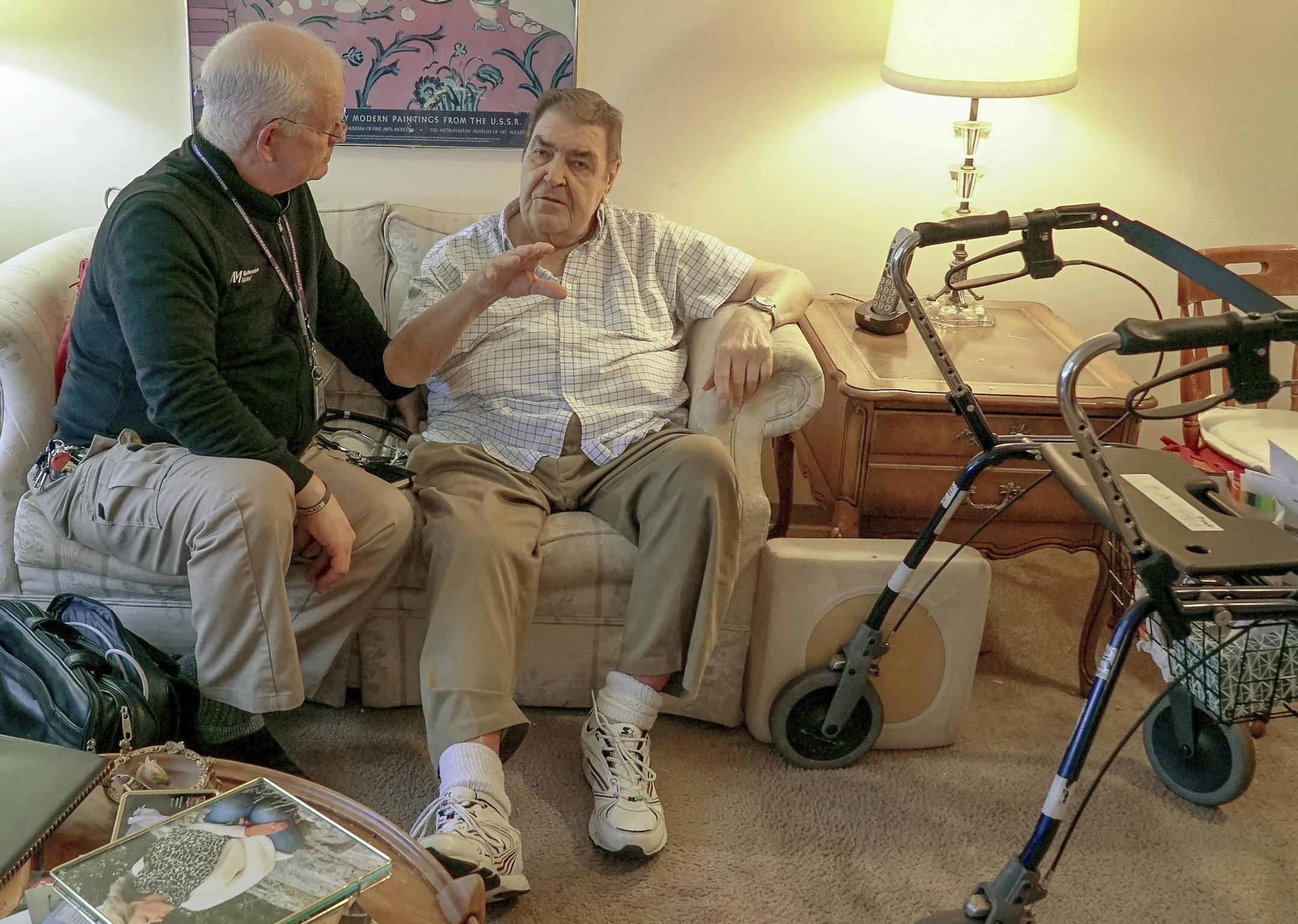 Nurse practitioner Dwayne Dobschuetz, left, visits patient Marvin Shimp, at Shimp's home in Chicago on Jan. 10, 2018. Shimp has lost much of his vision to macular degeneration and Dobschuetz's house calls help him stay out of the hospital with regular visits to check vitals and answer questions. Dobschuetz sees several patients in their homes each day, traveling by bicycle. He works at Northwestern Medicine in Chicago, which is taking a new approach to helping older patients stay healthier. (AP