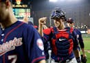 Minnesota Twins catcher Jason Castro high-fives teammates as he walks off the field after closing out a baseball game against the Baltimore Orioles in