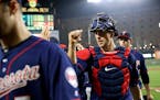 Minnesota Twins catcher Jason Castro high-fives teammates as he walks off the field after closing out a baseball game against the Baltimore Orioles in