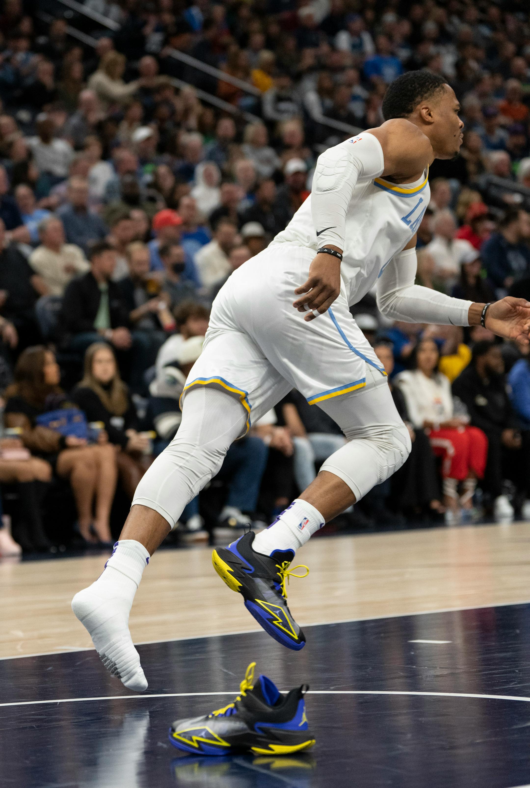 Los Angeles Lakers guard Russell Westbrook's (0) continues to play with one shoe after Minnesota Timberwolves center Karl-Anthony Towns (32) stood on the shoe pulling it off during his layup in the first quarter.