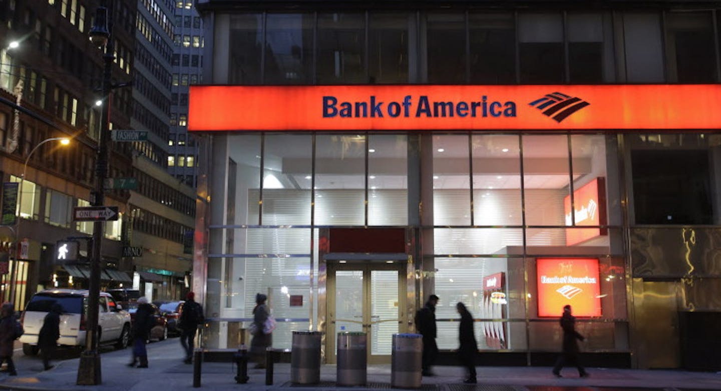 People walk past a branch of Bank of America, Wednesday, Jan. 14, 2015 in New York. The bank will report fourth-quarter and full-year results Thursday. (AP Photo/Mark Lennihan)