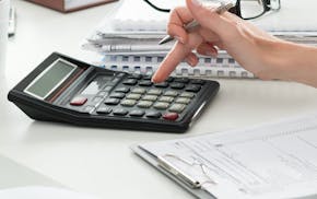 Close up of female accountant or banker making calculations. Savings, finances and economy concept. istock