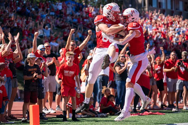 Saint John’s tight end Zach Jungles (39) celebrates with wide receiver Jimmy Buck (11) after Jungles scored a touchdown in the third quarter against