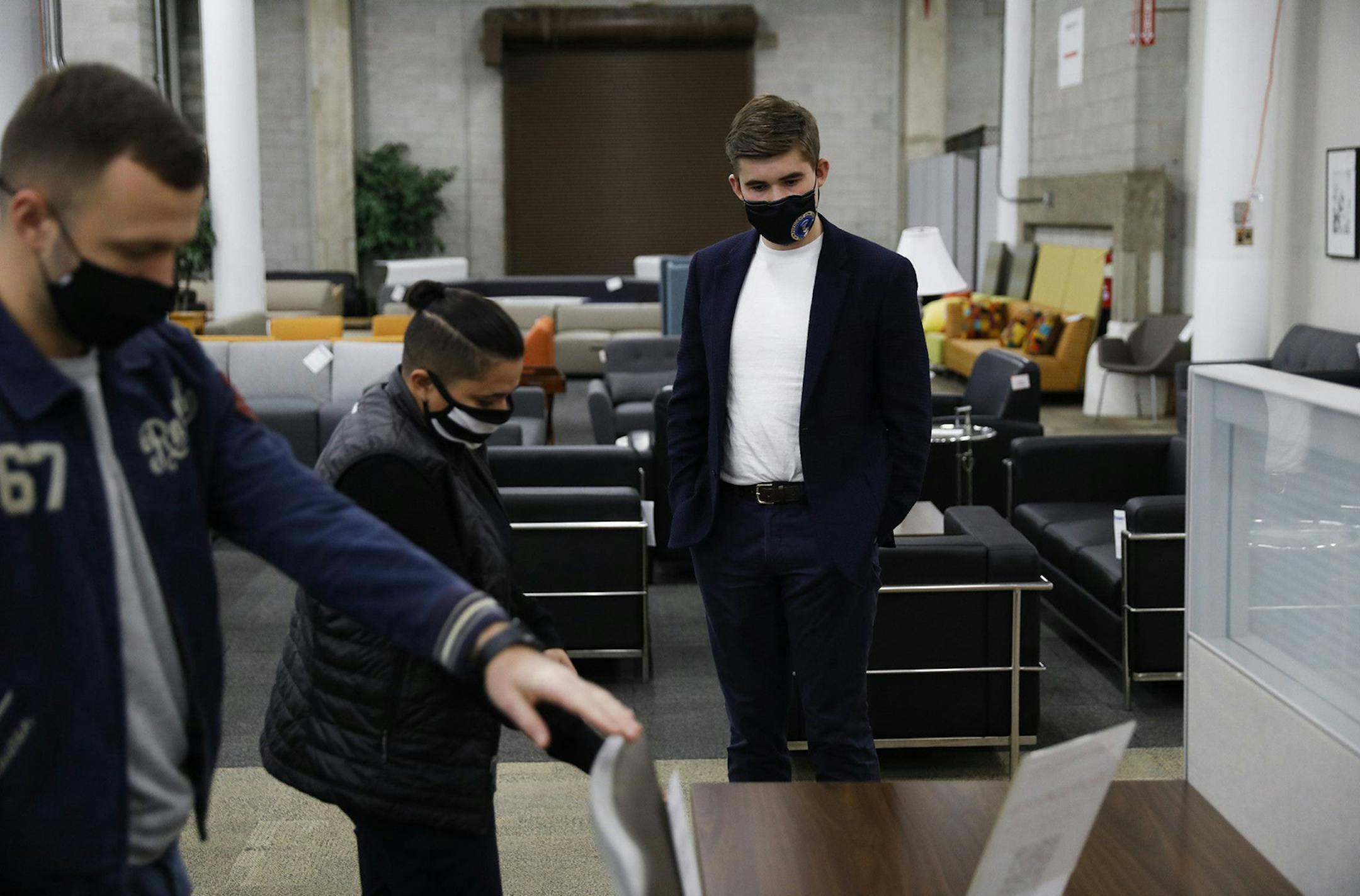 Andrew Sobko, right, and Viktor Tkachuk, left foreground, both with CDL 1000, shop for office workstations with the help of Grisell Feliciano, center, a workspace solutions specialist at Office Furniture Center in Chicago on Nov. 4, 2020. (Jose M. Osorio/Chicago Tribune/TNS) ORG XMIT: 1825532