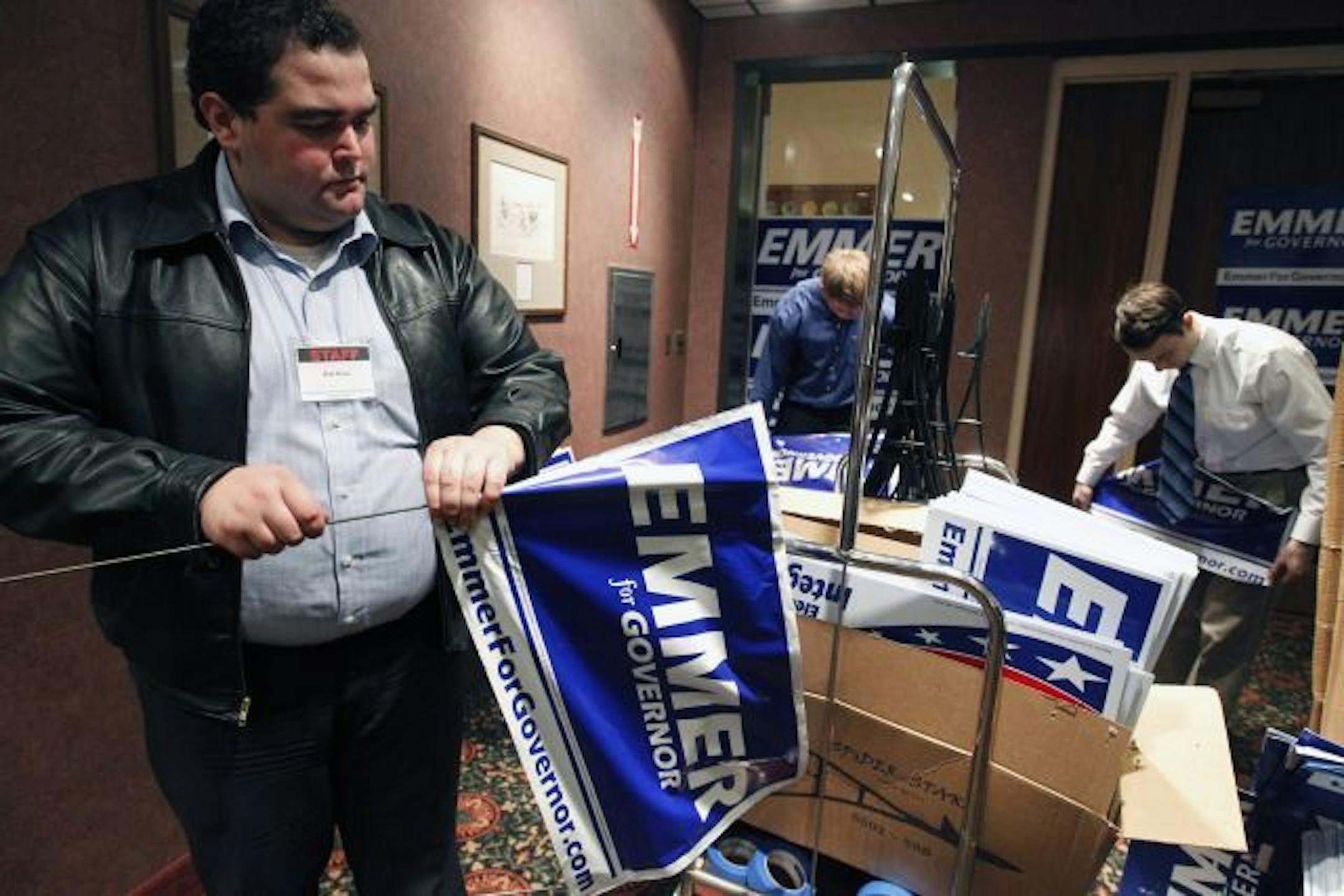 At the Mall of America Ramada, Bob Koss prepared some "Emmer for Governor" signs for a rally that featured former Massachusetts governor Mitt Romney who is campaigning for Emmer.